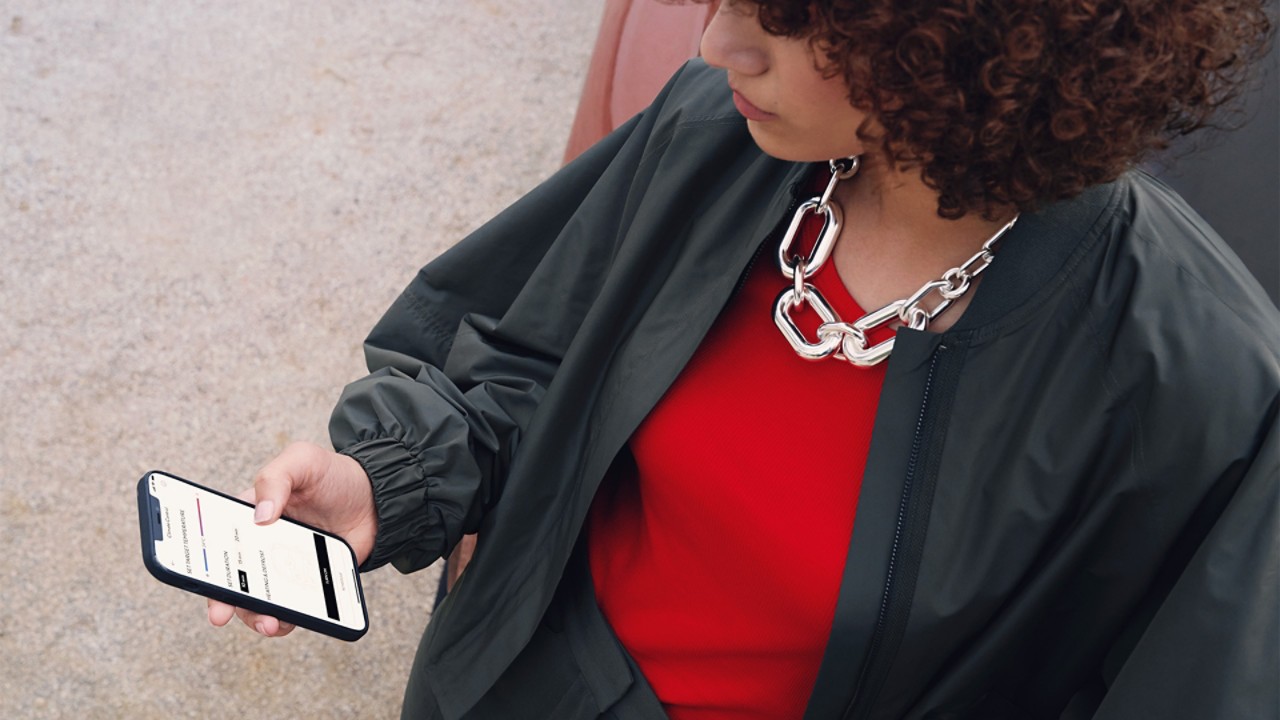 A woman using a mobile phone to access the Lexus Link app