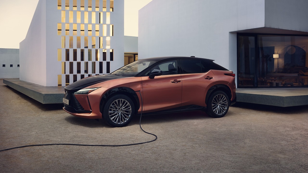 The Lexus RZ 450e charging in a driveway